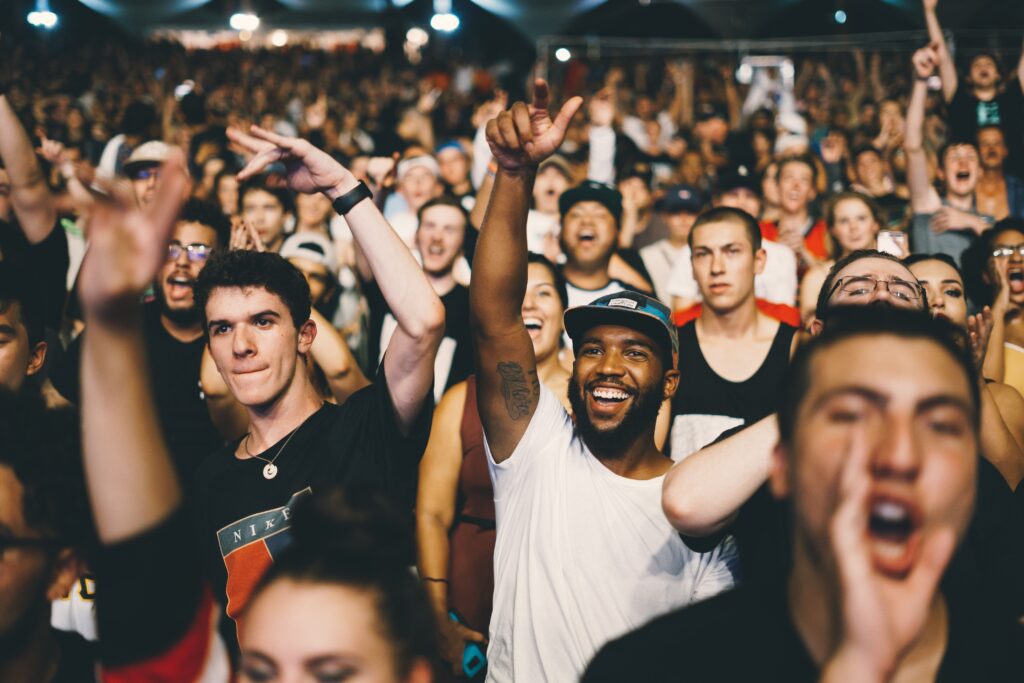 Fans smile and cheer at a concert.