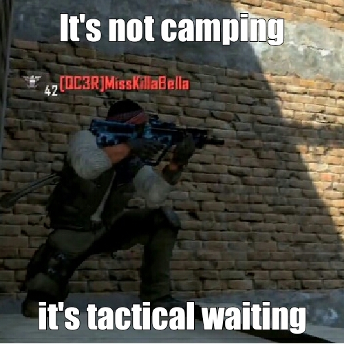 A screenshot from a first-person shooter game shows a player character crouching with a sniper rifle against a brick wall in a shadowed area. The in-game username '[OC3R] MissKillaBella' is displayed in red above the character. The meme text reads: 'It's not camping, it's tactical waiting.